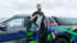 Mann in schwarzem T-Shirt lehnt an offenstehender Tür eines schwarzen Pickup-Trucks mit "Hausbau Saar" Logo.