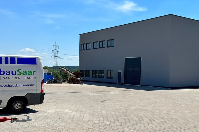 Weißer Transporter vor einem grauen Firmengebäude