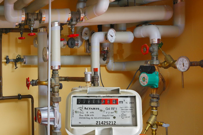 Heizungsraum mit Rohrleitungen, Umwälzpumpe, Manometer und Gaszähler